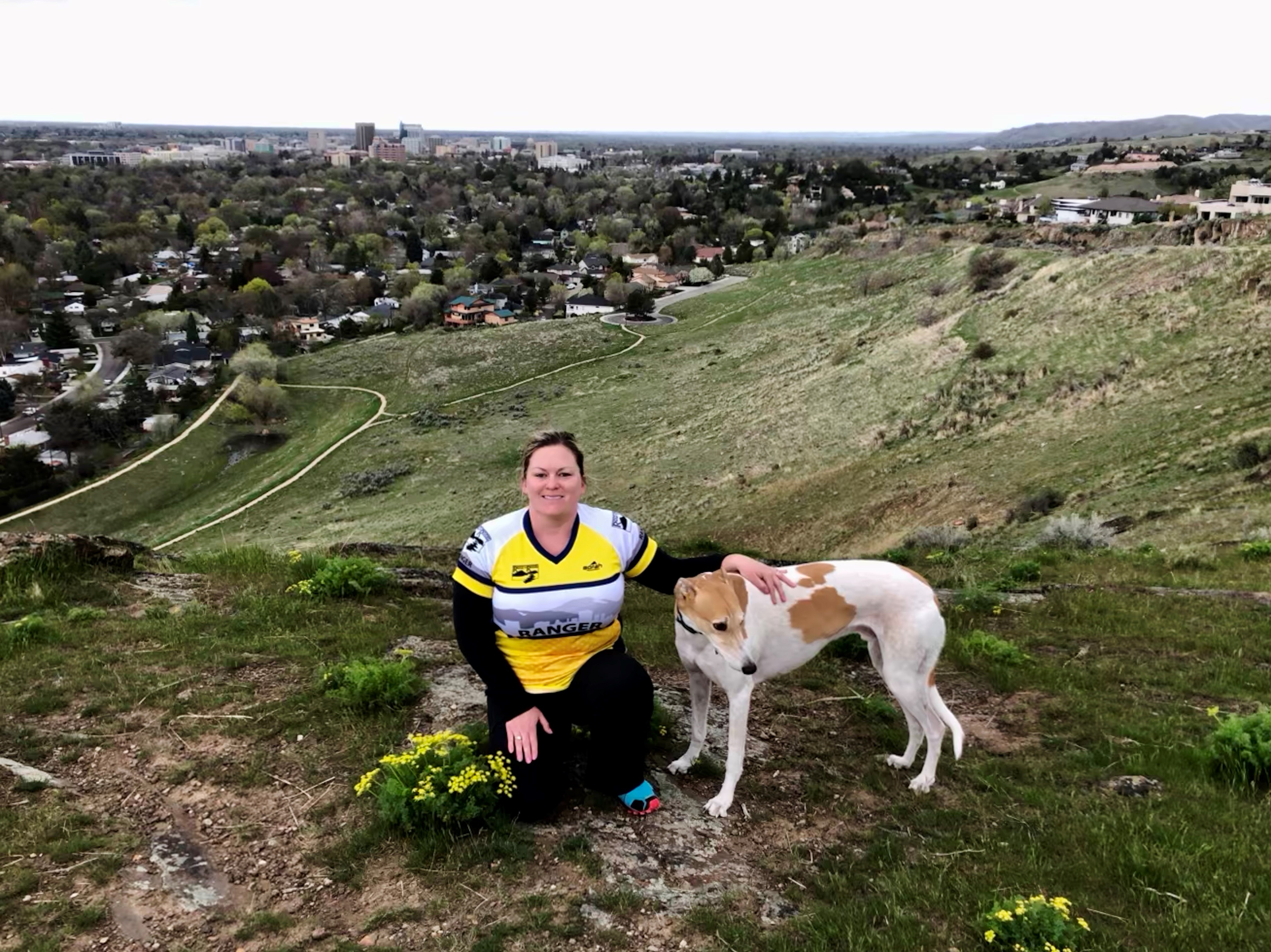 A Volunteer Trail Ranger and dog on a hill overlooking the Ridge to Rivers trail system.
